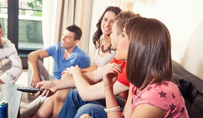 Students in an apartment watching TV.